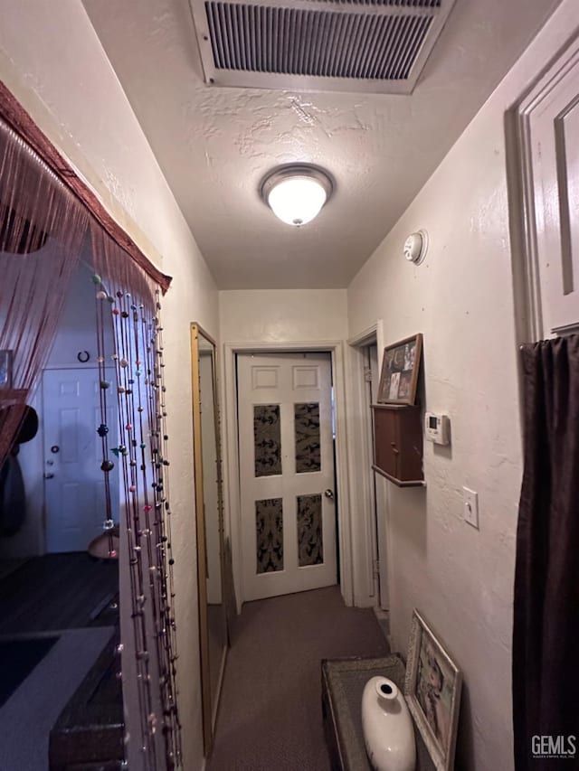 hall featuring a textured ceiling