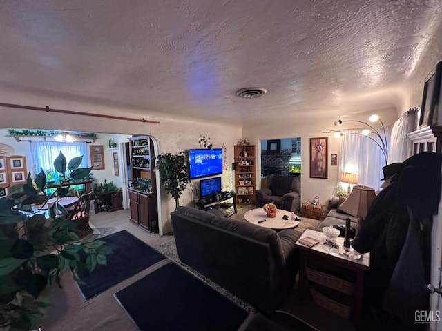 carpeted living room with a fireplace and a textured ceiling