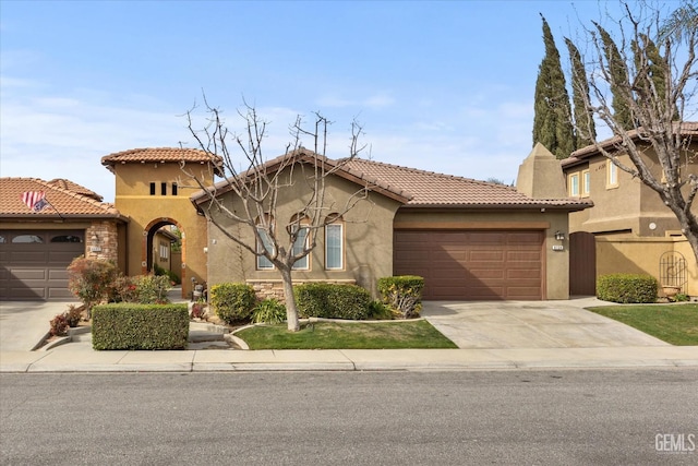 mediterranean / spanish-style house featuring a chimney, stucco siding, an attached garage, driveway, and a tiled roof