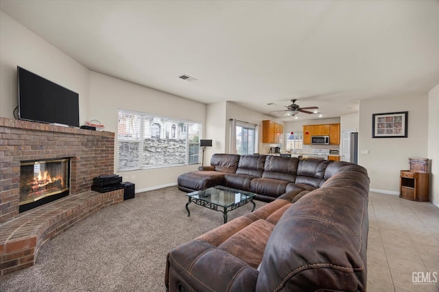 living room featuring a healthy amount of sunlight, a fireplace, visible vents, and light tile patterned flooring