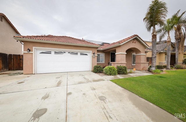 mediterranean / spanish-style home with a garage, a front lawn, and solar panels