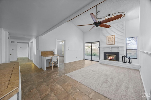 unfurnished living room with high vaulted ceiling, ceiling fan, a fireplace, and baseboards