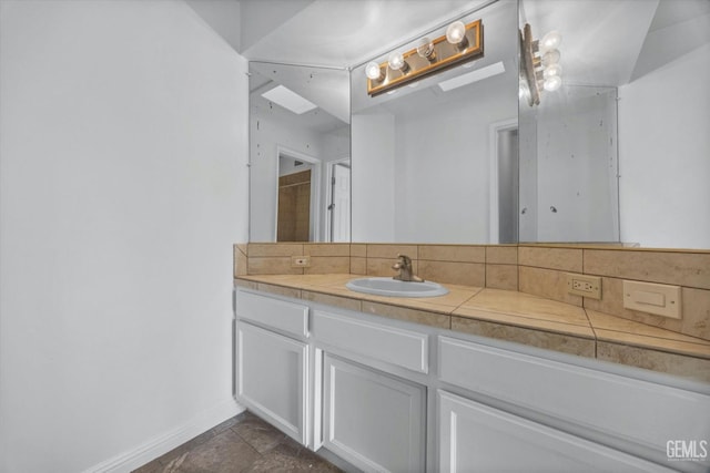 bathroom with baseboards, backsplash, and vanity