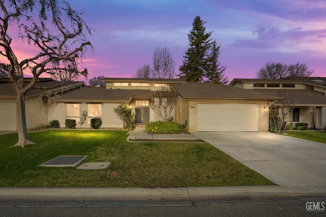 mid-century home featuring an attached garage, a front lawn, concrete driveway, and stucco siding