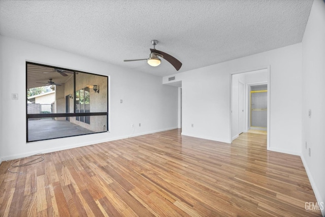 unfurnished room featuring visible vents, light wood finished floors, a textured ceiling, and a ceiling fan