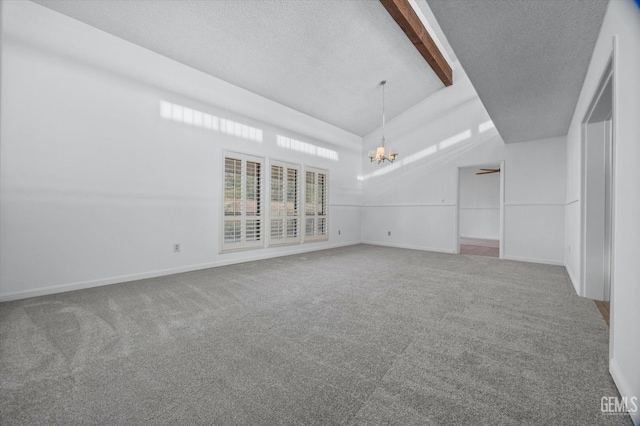 carpeted spare room featuring baseboards, a chandelier, and a textured ceiling