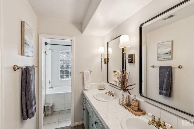 bathroom featuring tiled tub, tile patterned flooring, and vanity