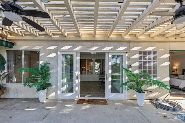 entrance to property featuring a pergola, ceiling fan, and a patio area