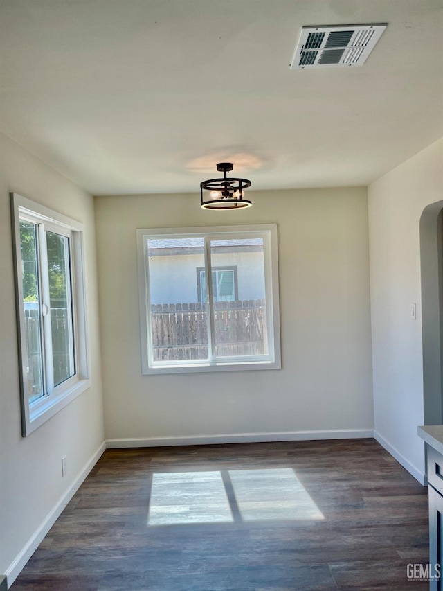 656 Minter Ave, Shafter, CA 93263 - spare room featuring dark wood finished floors, arched walkways, and a chandelier