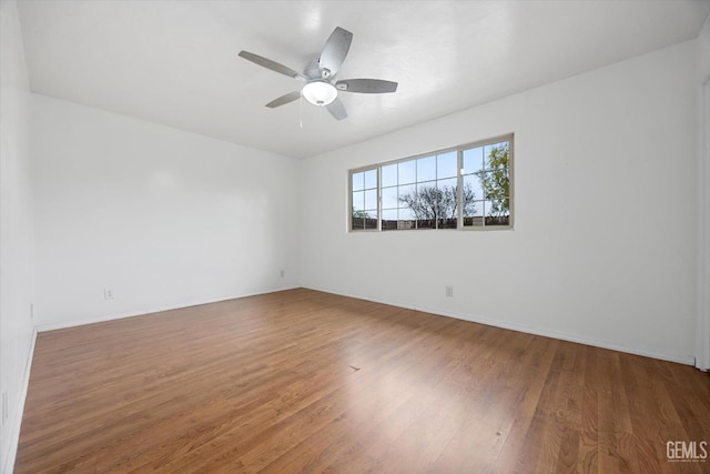 spare room with ceiling fan, baseboards, and wood finished floors