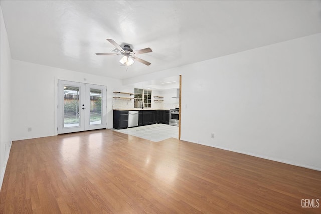 unfurnished living room featuring light wood-style floors, french doors, and a ceiling fan