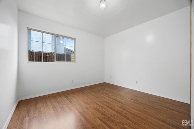 empty room featuring baseboards and wood finished floors