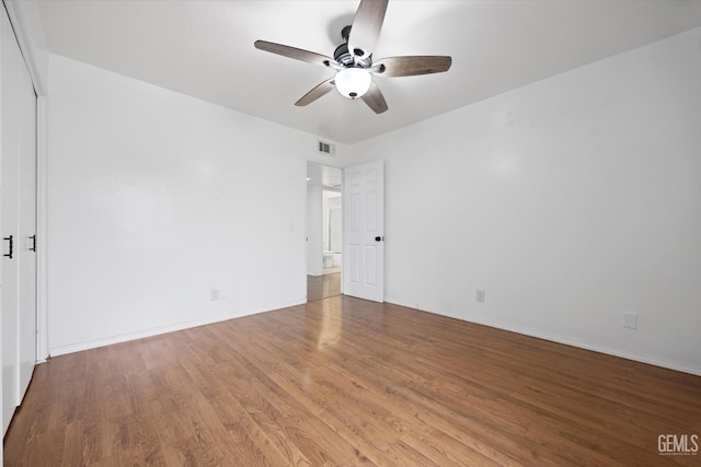 unfurnished bedroom with a ceiling fan, visible vents, baseboards, and wood finished floors