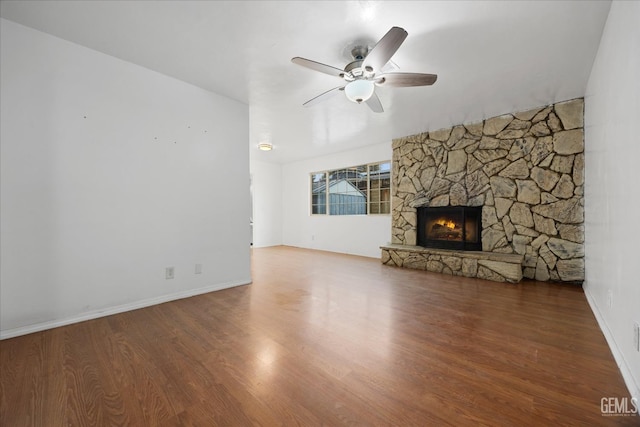 unfurnished living room with a ceiling fan, a fireplace, baseboards, and wood finished floors