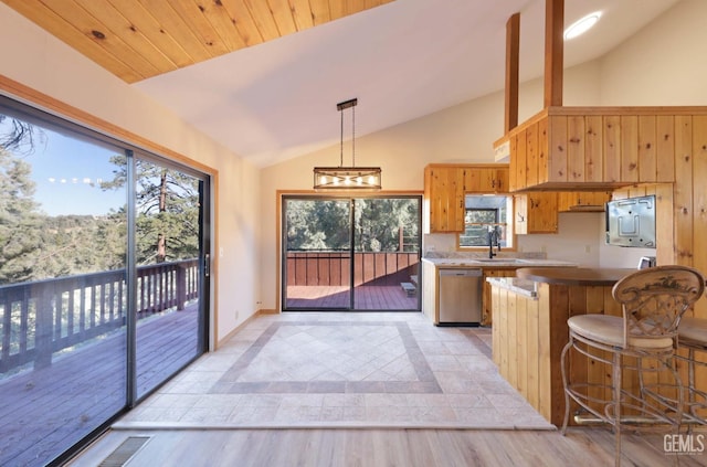 kitchen featuring dishwasher, kitchen peninsula, light hardwood / wood-style floors, decorative light fixtures, and lofted ceiling