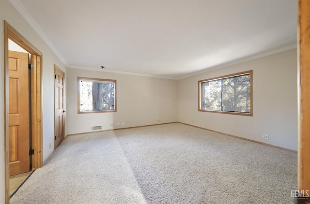 empty room with crown molding and light carpet