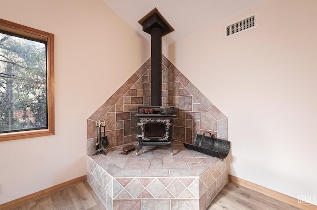 interior details with hardwood / wood-style flooring and a wood stove