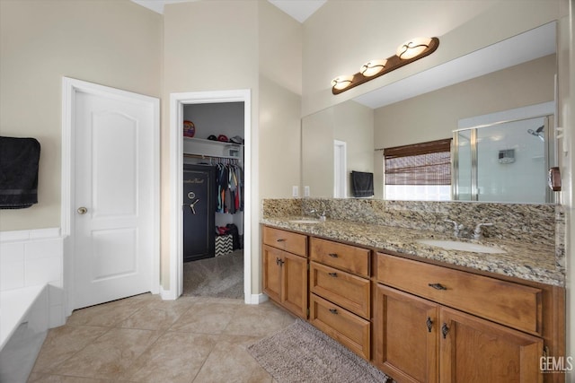 bathroom with double vanity, a sink, a garden tub, and a shower stall