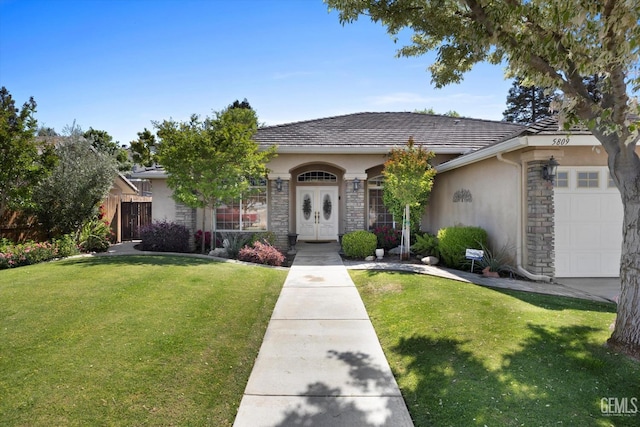single story home featuring fence, an attached garage, stone siding, stucco siding, and a front yard