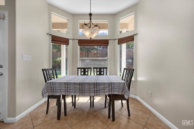 dining space featuring baseboards, a towering ceiling, and light tile patterned floors