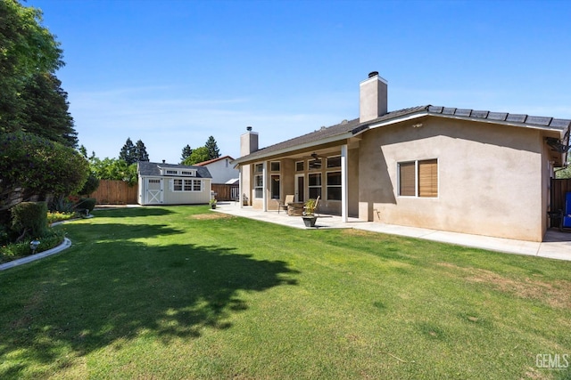 rear view of house featuring a storage shed, a fenced backyard, a patio area, a ceiling fan, and an outdoor structure