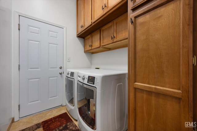 clothes washing area with separate washer and dryer, cabinet space, and light tile patterned flooring