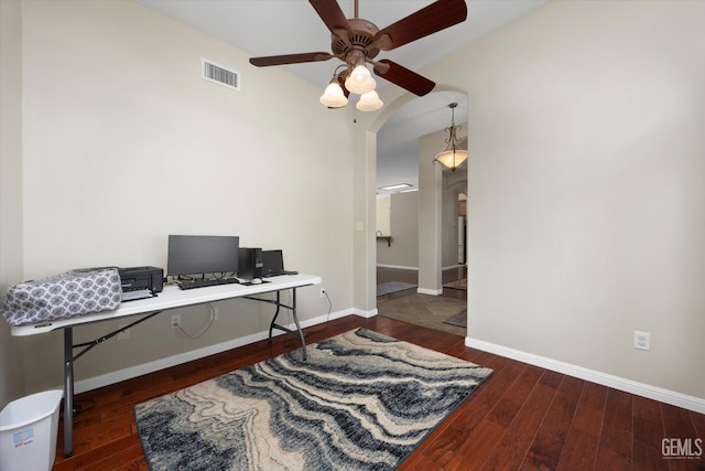 office featuring ceiling fan, visible vents, arched walkways, wood finished floors, and baseboards