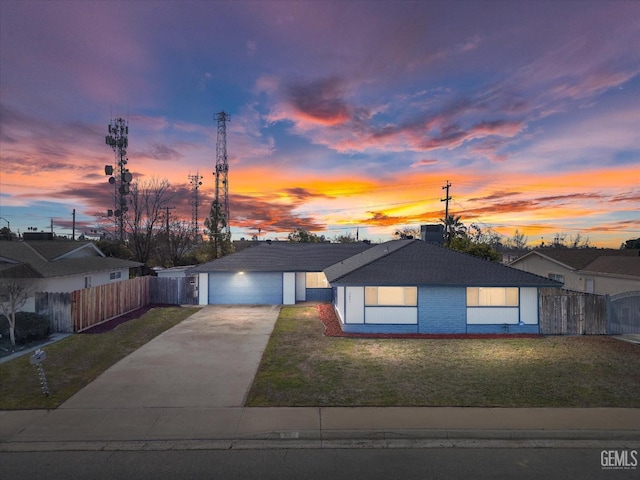 view of front of property with a garage, concrete driveway, a front yard, and fence