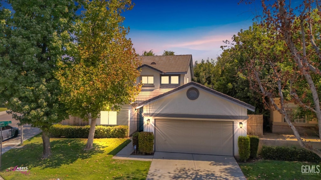 view of front of home featuring a garage and a yard