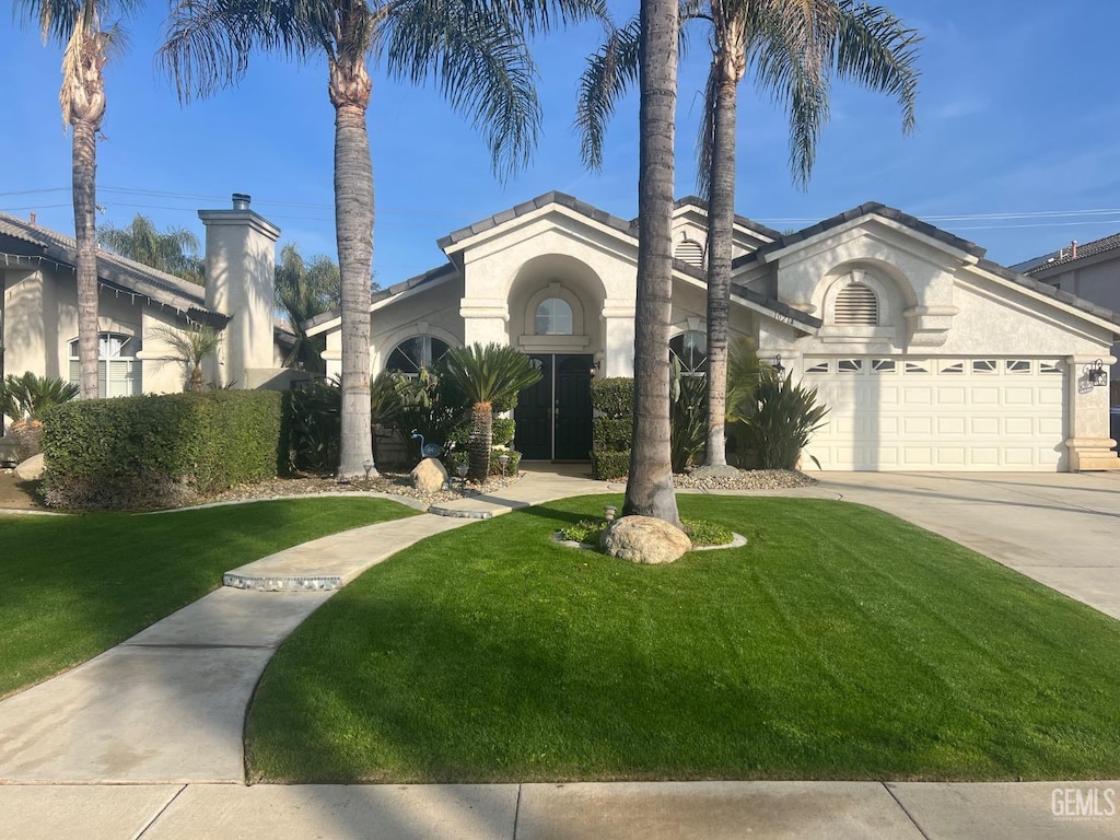 view of front of house with a garage and a front lawn