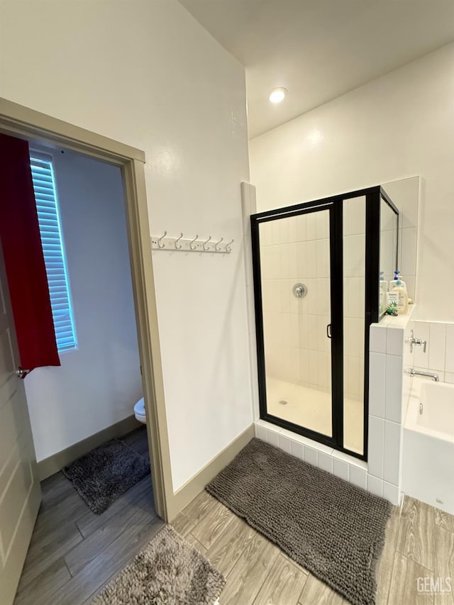 5917 Hawthorn Tree Ln, Bakersfield, CA 93313 - bathroom with a bath, a stall shower, wood finished floors, and toilet