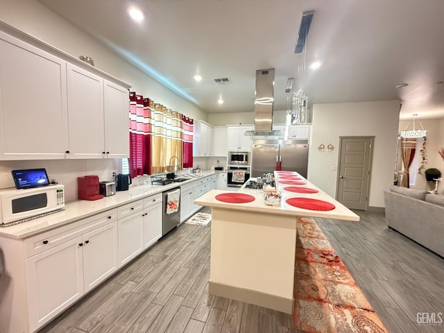 5917 Hawthorn Tree Ln, Bakersfield, CA 93313 - kitchen with appliances with stainless steel finishes, light wood-type flooring, light countertops, white cabinetry, and a center island