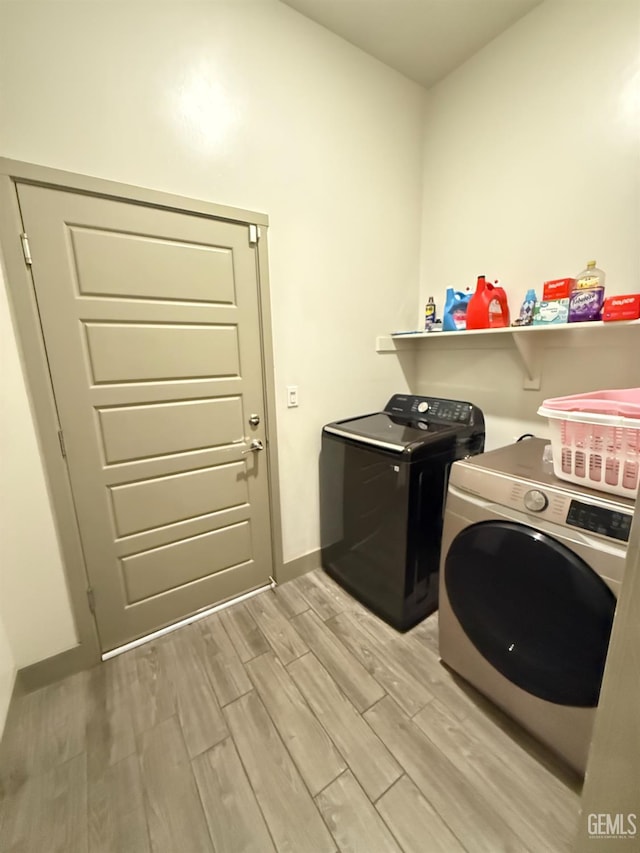 5917 Hawthorn Tree Ln, Bakersfield, CA 93313 - laundry area featuring washer and clothes dryer, light wood-style flooring, and baseboards