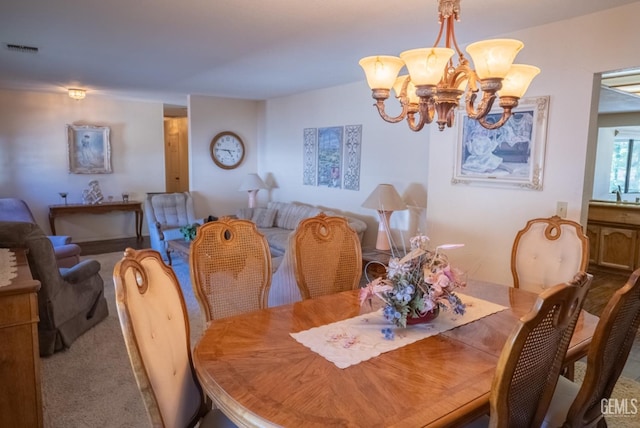 carpeted dining room featuring a notable chandelier