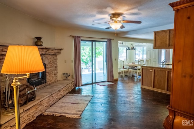 living room with ceiling fan with notable chandelier, a textured ceiling, dark hardwood / wood-style flooring, and sink