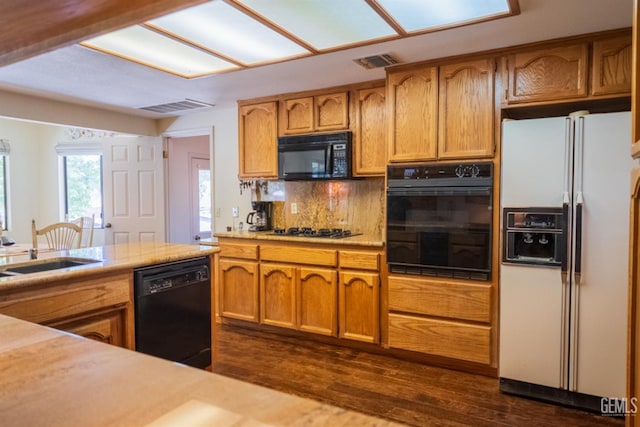 kitchen featuring backsplash, dark hardwood / wood-style flooring, sink, and black appliances