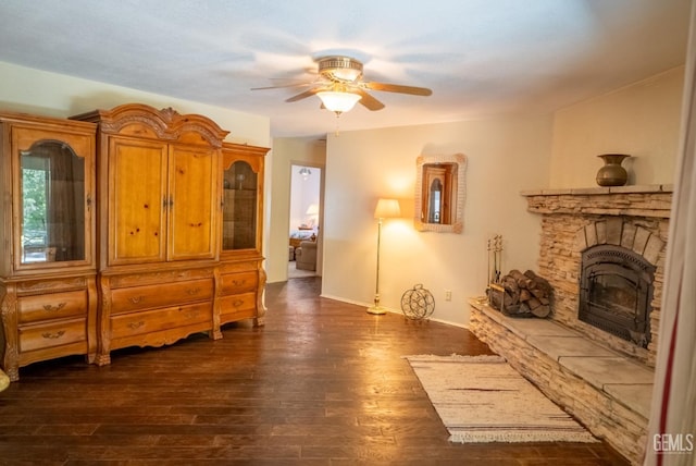 interior space featuring a fireplace, dark hardwood / wood-style floors, and ceiling fan