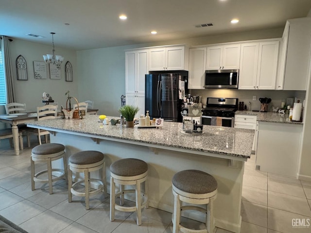 kitchen with light stone counters, light tile patterned floors, stainless steel appliances, recessed lighting, and white cabinets