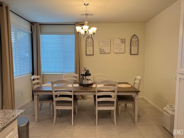 dining space with visible vents, a notable chandelier, baseboards, and light tile patterned floors