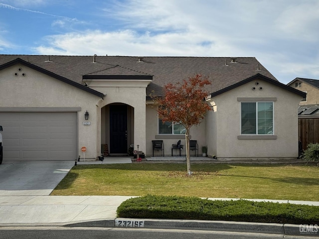 view of front of property with an attached garage, a shingled roof, concrete driveway, stucco siding, and a front lawn