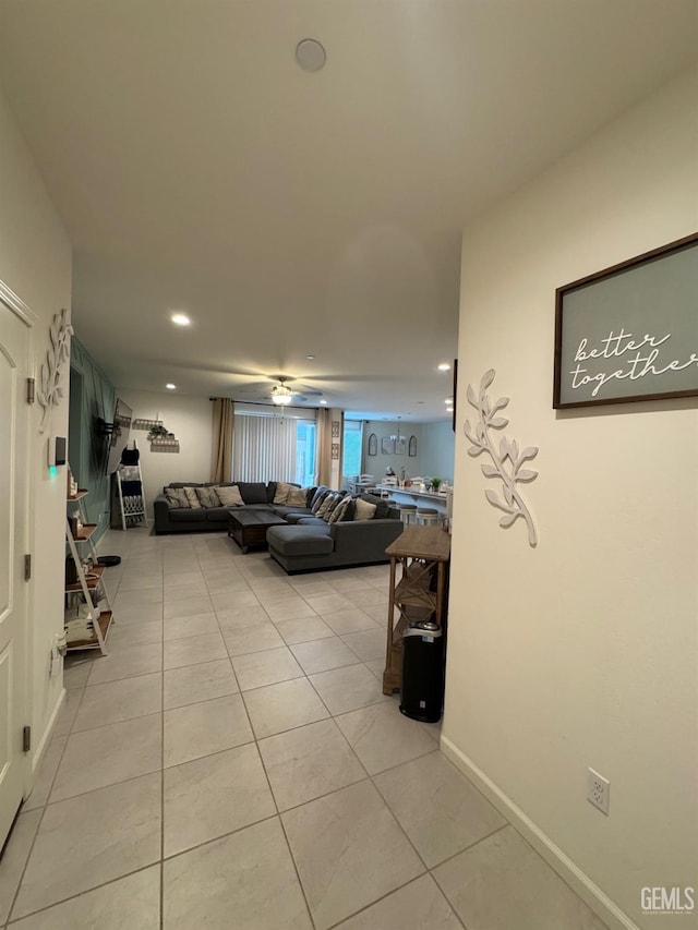 living area featuring baseboards, light tile patterned flooring, a ceiling fan, and recessed lighting