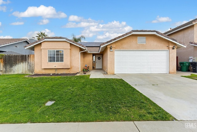 single story home with a front lawn, roof mounted solar panels, stucco siding, driveway, and an attached garage