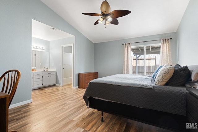 bedroom featuring visible vents, baseboards, light wood-type flooring, lofted ceiling, and ensuite bathroom