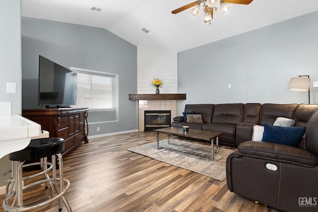 living room featuring visible vents, wood finished floors, a ceiling fan, and vaulted ceiling