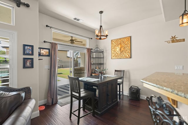 dining room featuring dark hardwood / wood-style flooring and ceiling fan with notable chandelier