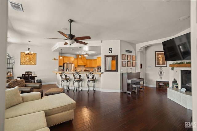 living room with dark wood-type flooring and ceiling fan