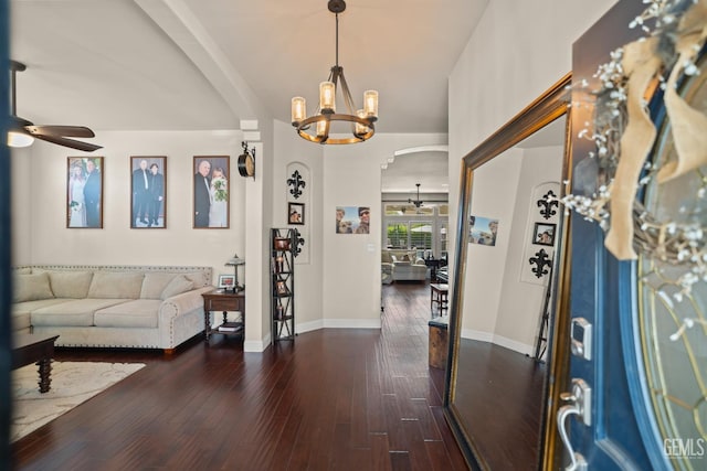 foyer featuring dark wood-type flooring and ceiling fan with notable chandelier