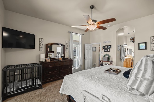 carpeted bedroom with connected bathroom and ceiling fan