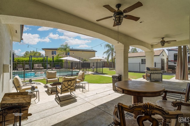 view of patio featuring ceiling fan, grilling area, and a fenced in pool