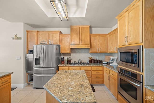 kitchen featuring tasteful backsplash, light stone countertops, appliances with stainless steel finishes, and light tile patterned flooring